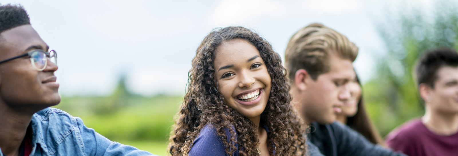 Group of friends with one woman looking at the camera and smiling